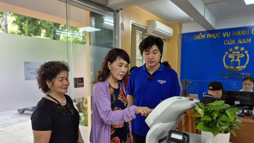 Người dân trải nghiệm Robot AI hỗ trợ thực hiện các thủ tục hành chính tại phường Cửa Nam, thành phố Hà Nội. (Ảnh NGUYỄN THẮNG)