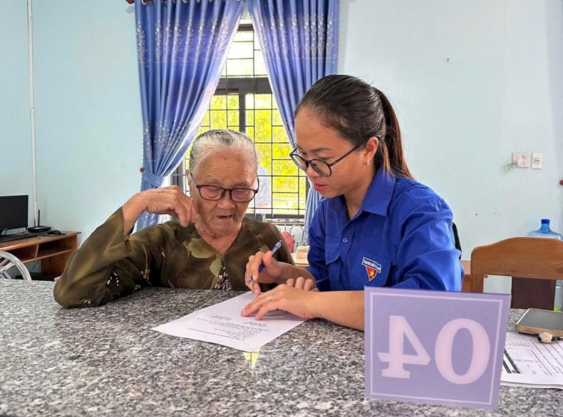 Thanh niên tình nguyện hướng dẫn người dân Hòa Thắng làm TTHC. Ảnh PN