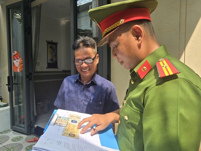 Cán bộ CSGT hướng dẫn người dân kê khai thông tin và chuyển đổi giấy phép lái xe sang thẻ PET - một phần trong kế hoạch làm sạch dữ liệu và số hóa quản lý phương tiện tại TP Hồ Chí Minh.