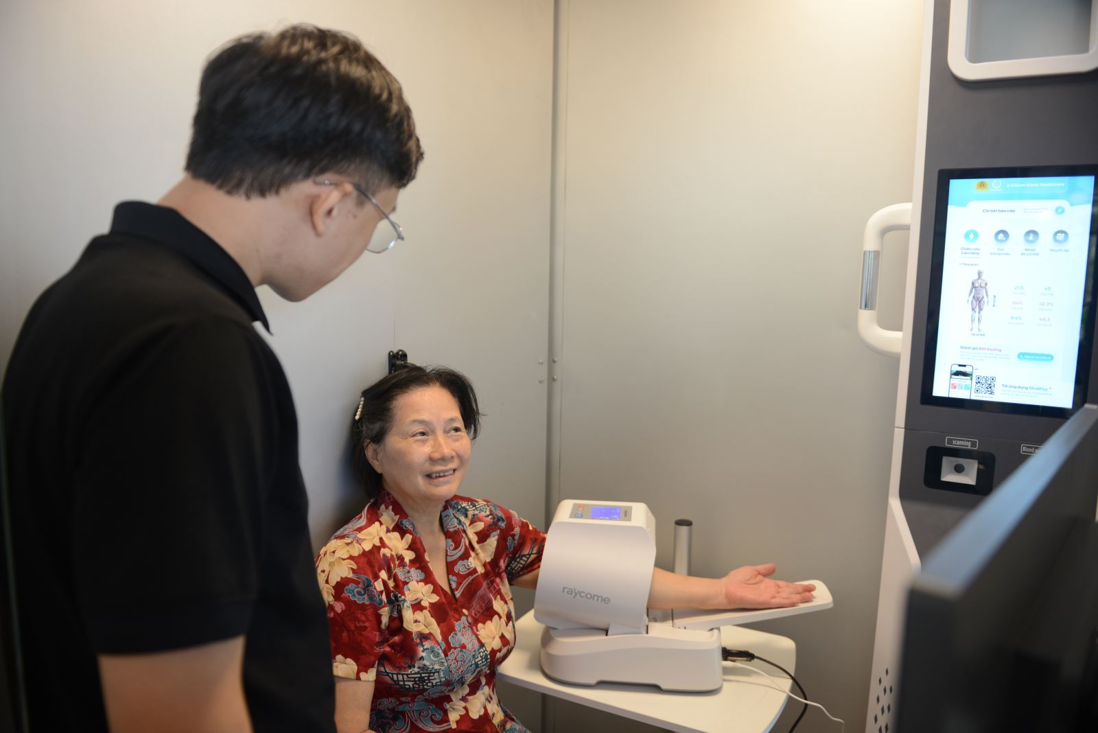 Cán bộ công an hỗ trợ người cao tuổi trải nghiệm các dịch vụ công trực tuyến tại “Trạm công dân số”.