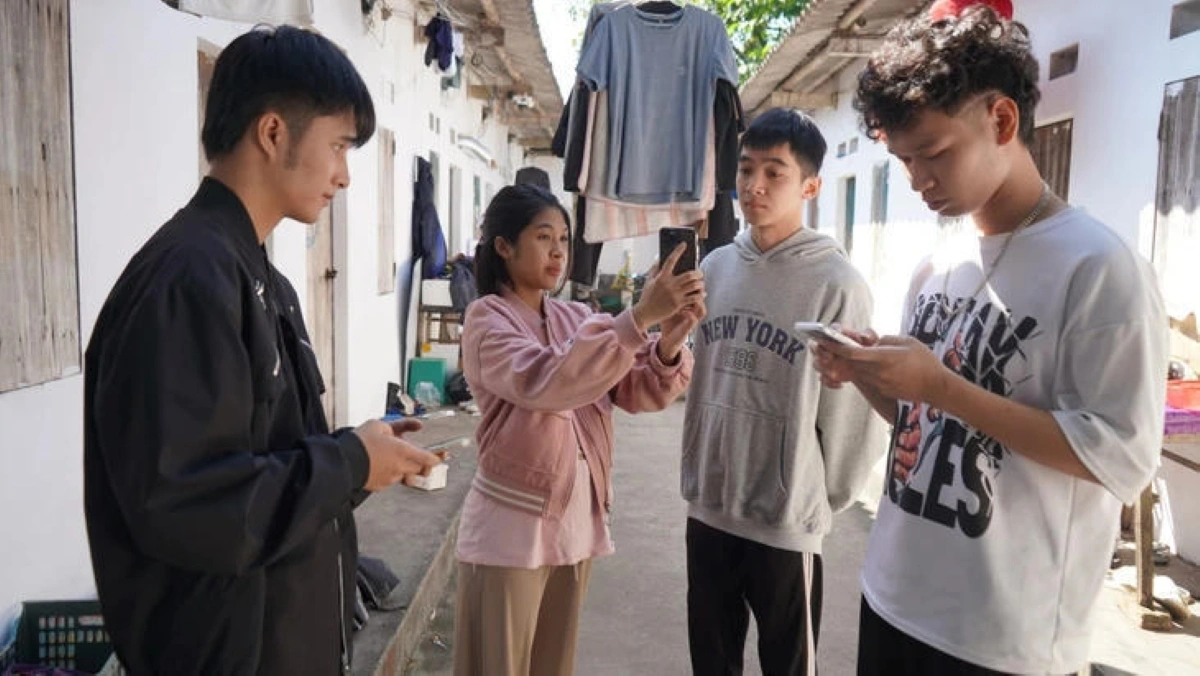 Nguyễn Ngọc Bích Thủy mô phỏng lại việc quét dữ liệu khuôn mặt của bị hại để tạo lập hồ sơ vay tiền online. Ảnh: Công an cung cấp.