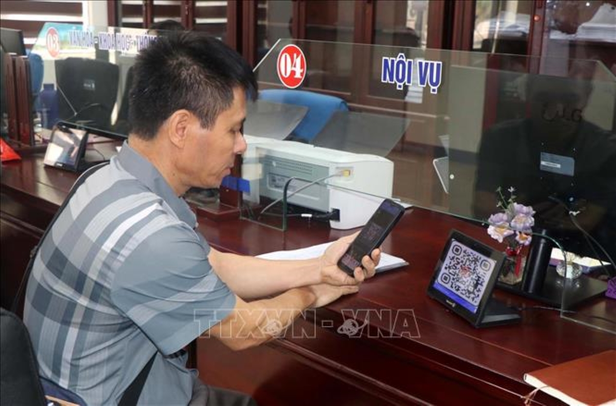 Người dân sử dụng điện thoại thông minh để quét QR-Code thực hiện các thủ tục hành chính. Ảnh: TTXVN
